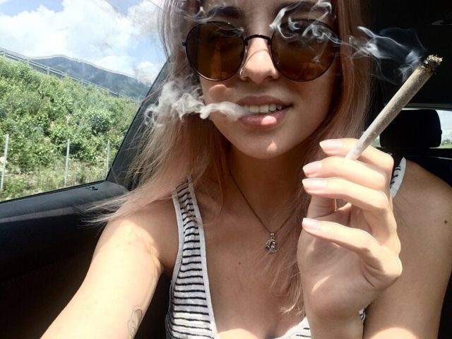 blonde girl in car smoking weed