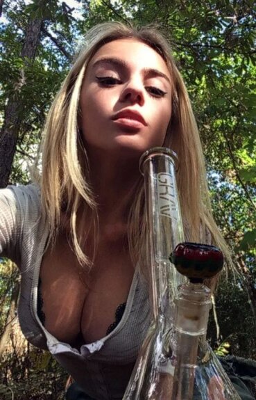 blonde girl with cleavage smoking bong