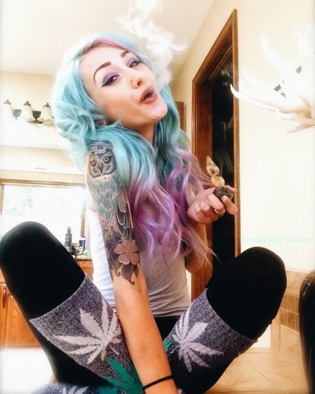 blue and pink haired girl smoking weed pipe